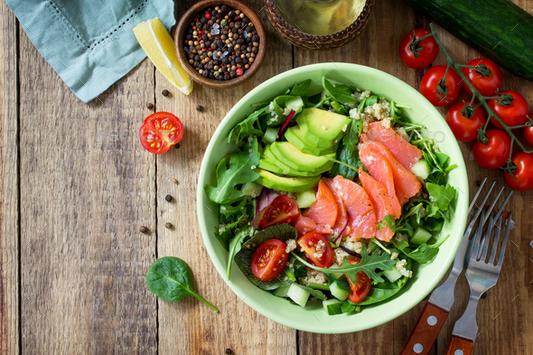 Diet menu, Vegan food. Healthy salad with quinoa, arugula, Tomatoes, Salmon and Avocado.