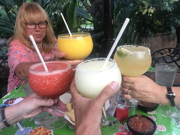 A group of women make a toast with frozen margaritas at a Mexican restaurant.