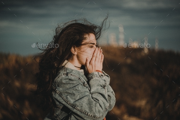 Windy weather and a young woman with a long and dark hair - Stock Photo - Images