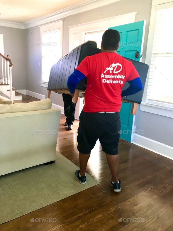 Two movers from moving company moving furniture