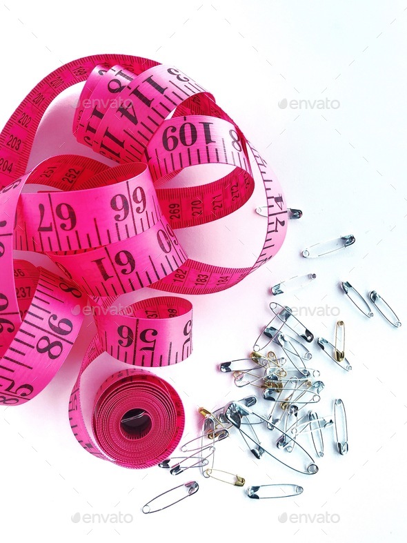 Pink measuring tape and safety pins for sewing or costumes Stock Photo by  breejeanjohnson