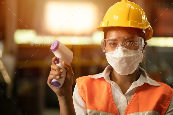 Industry women worker wear face mask and checking body temperature during Coronavirus (COVID-19) pan