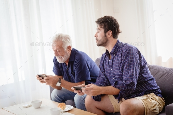 Senior old man father playing game with son family happy moment at home.