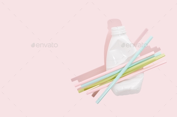 Negative impact on nature. Plastic bottles, straws on a minimalistic pink background. Soil pollution