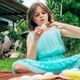 Cute little girl is painting Easter egg with her finger sitting on blanket on the grass in backyard - PhotoDune Item for Sale