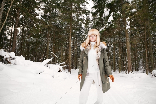 Happy girl walk in winter snowy forest