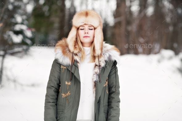 Woman with closed eyes in winter forest
