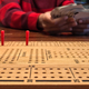 Close up of wooden Cribbage board with young boy’s hands shuffling the cards  - PhotoDune Item for Sale