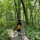 Young mixed race boy hiking through the woods wearing a yellow drawstring bag on his back  - PhotoDune Item for Sale
