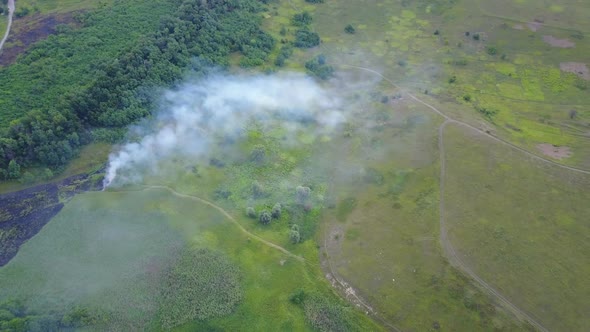 Flight Through a Smoke Over Burning Green Field, Wild Fire in Nature Landscape, Aerial Footage From alt