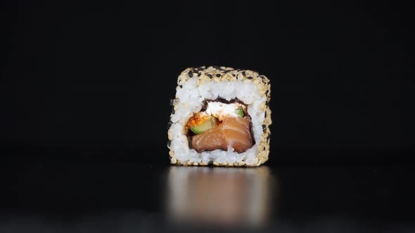 The Sushi Roll Falls Down Onto a Black Surface. Maki Falls in Large Numbers. Rain of Japan's Food.