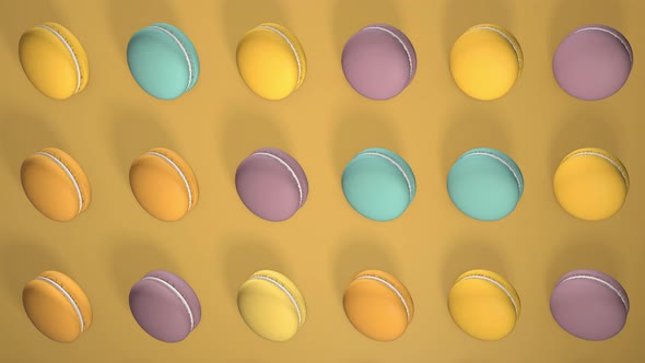 Multicolored macaron pastries on light yellow paper background