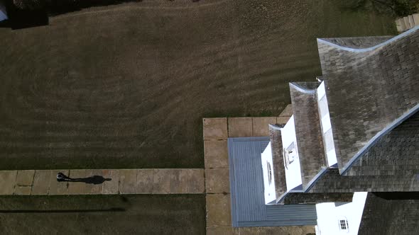 Drone hovering closely above St Boniface catholic church in Canadian countryside while filming a per alt