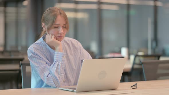 Tired Young Woman Taking Nap While Sitting in Office with Laptop alt