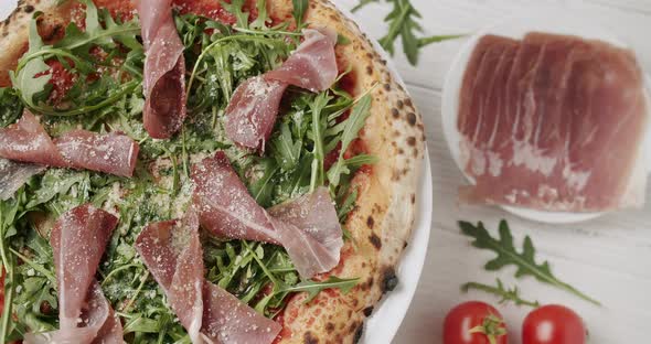 Delicious Pizza with Prosciutto Parma Ham Arugula Salad Rocket with Ingredients alt
