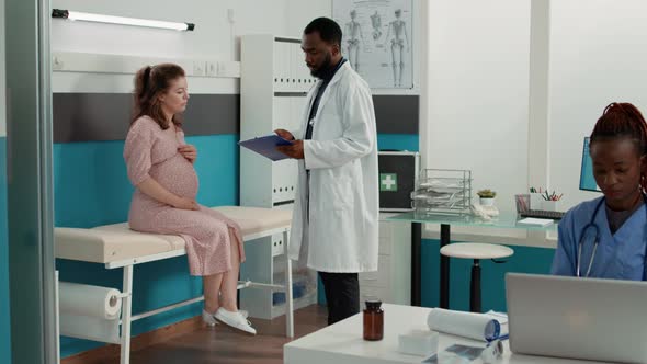 General Practitioner Attending Consultation with Pregnant Woman alt