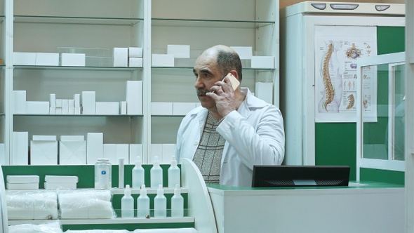 Pharmacist Consulting Customer via Cell Phone in Drug Store