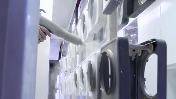 Man Paints Metal Products From a Spray Gun White Paint alt