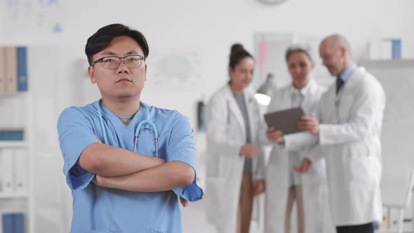 Confident Asian Doctor Crossing Hands alt