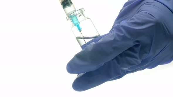Syringe Needle with Medical Bottle in the Hand Isolated on White Background