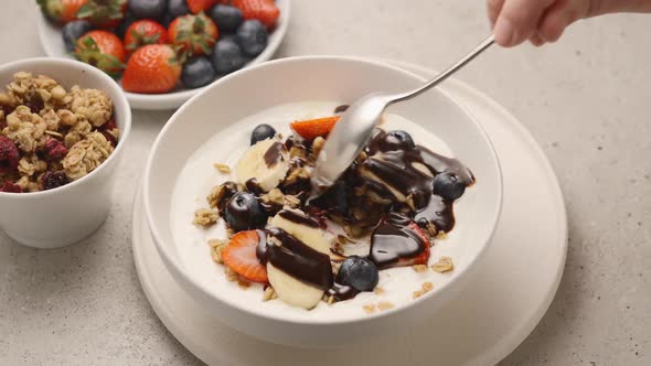 Muesli with yogurt, fresh berries and chocolate sauce