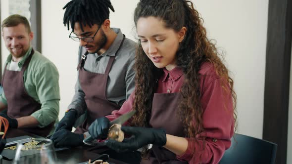 Group of Young Girls and Guys in Aprons and Gloves Cooking Food in Kitchen Talking Laughing alt