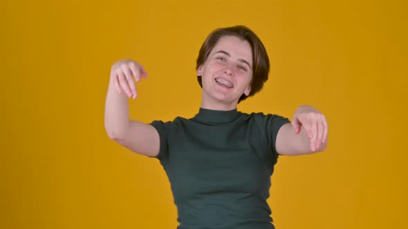 Young cheerful girl in t-shirt smiling dancing and looking at the camera