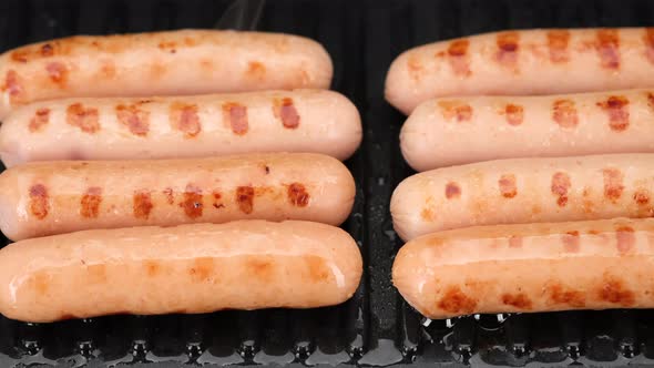 frying sausages on grill close up. 4K UHD video