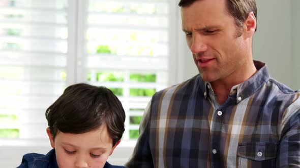 Father helping son with school homework alt