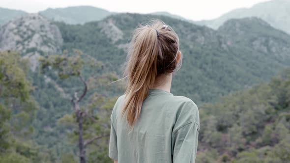 Rear View of a Woman Alone on the Mountain High Enjoying the View alt