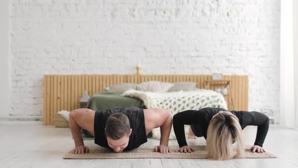 Fitness Couple Doing Push Up Exercises Together on Workout at Home Front View