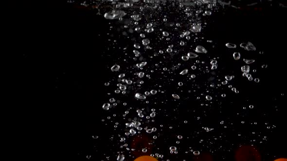 Closeup of fresh and health cherry tomatoes falling into clear water with big splash  alt