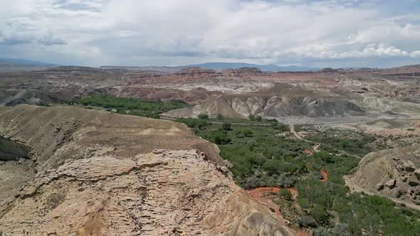 Flying over the desert and red Fremont River from summer monsoon storm alt