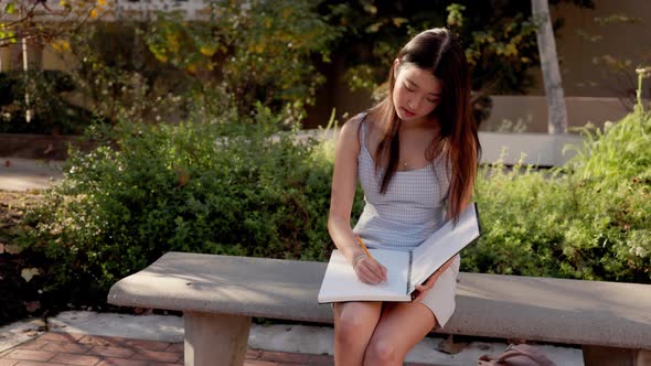 Asian female college student working on her homework alt