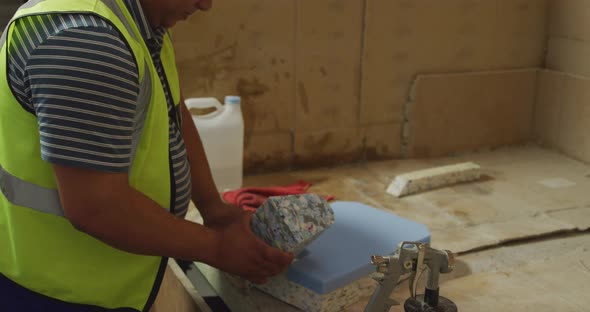 Worker assembling pieces of concrete block alt