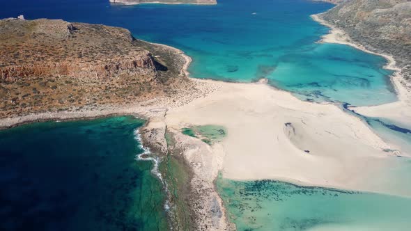 AERIAL: Beautiful white sand beach with turquoise water. Sunny summer day. Paradise. Crete, Greece alt