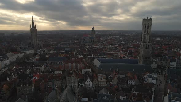 Aerial approach of three towers in Bruges' skyline alt