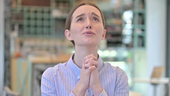Portrait of Hopeful Young Businesswoman Praying alt