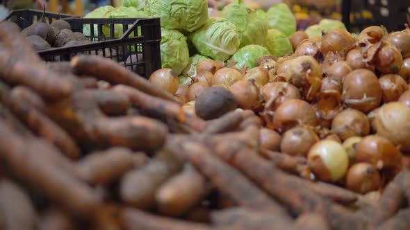 Woman Buying Vegetables in Supermarket Carrot Onion and Cabbage on Shelves