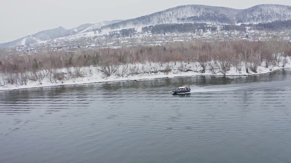 Aerial Shots of a Hovercraft Traveling Fast Along the River Near the Shore alt