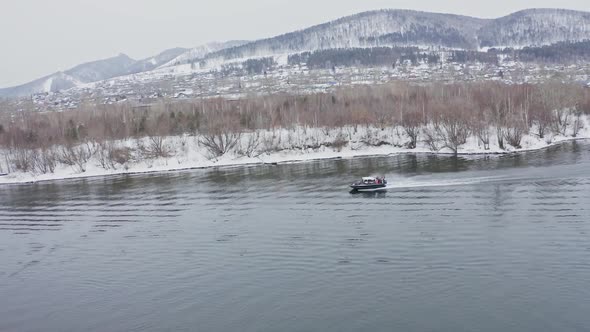 Aerial Shots of a Hovercraft Traveling Fast Along the River Near the Shore