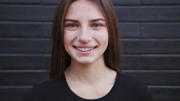 An Attractive Young Lady Straightens Her Hair and Smiles Outdoors. Close-up Shot alt
