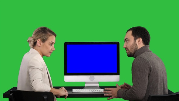 Business people having meeting around monitor of computer alt