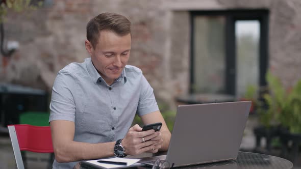 Closeup a Man with a Mobile Phone is Engaged in Online Banking Buys on the Internet and Writes alt