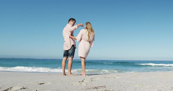 Couple in love enjoying free time on the beach together alt
