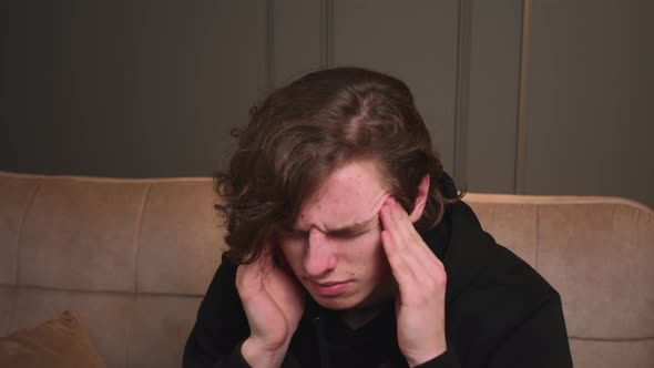 Portrait Young Man Feeling Bad While Sitting on Sofa at Home alt