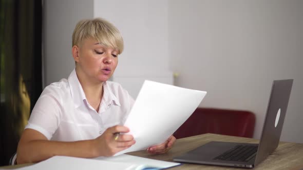 The Serious Blonde Middle Age Woman Head is Holding an Online Meeting