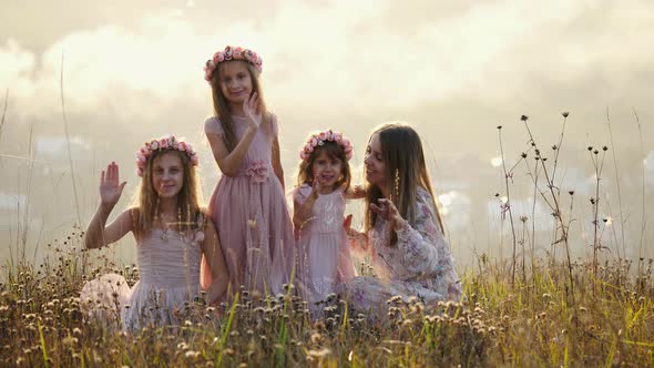 Mother and daughters waving hands alt