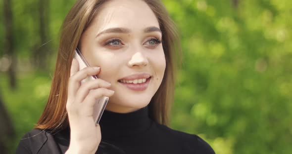 Portrait of Beautiful Female Talking Phone and Laughing While Looking Away alt