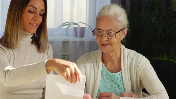 Woman Helping Grandmother to Read a Letter